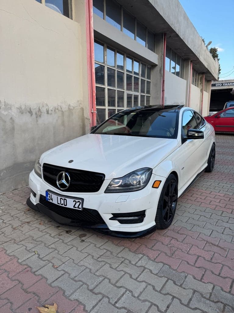 Foto van een witte coupé buiten, van schuin vooraan. Dit is een referentie voor de invoerfoto, geen gegenereerd resultaat.